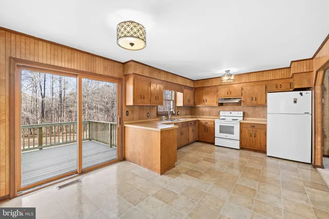 a kitchen with cabinets appliances a sink and a window