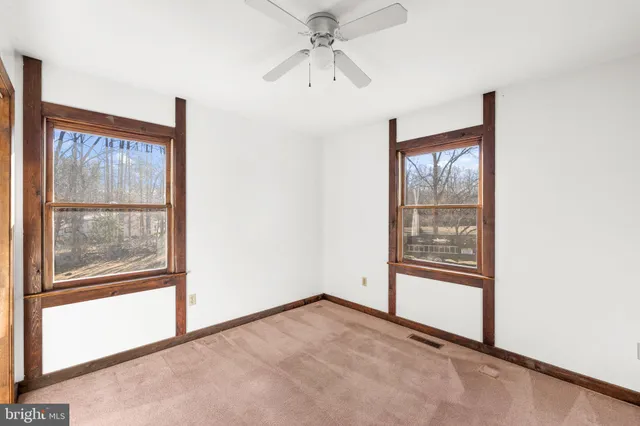 a bedroom with a bed and a dresser next to a window