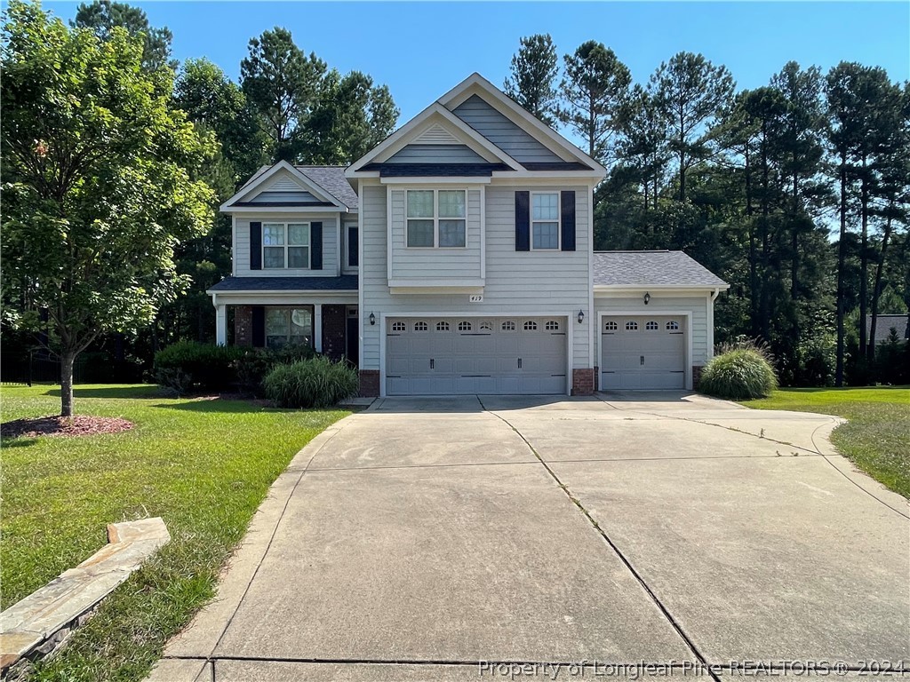 a front view of a house with a yard and trees