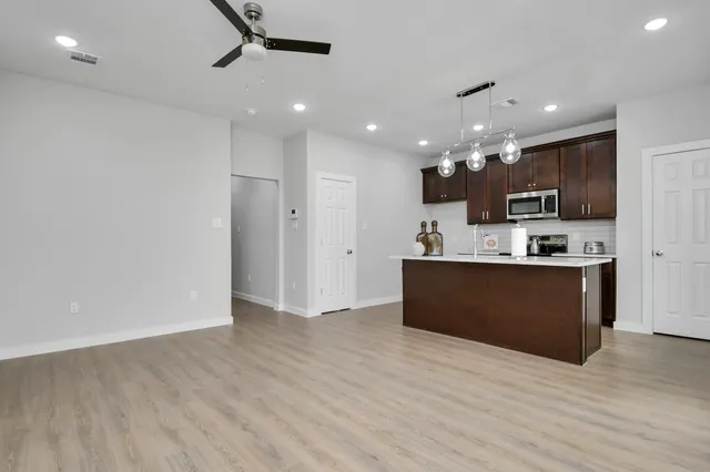 a view of kitchen with refrigerator and microwave