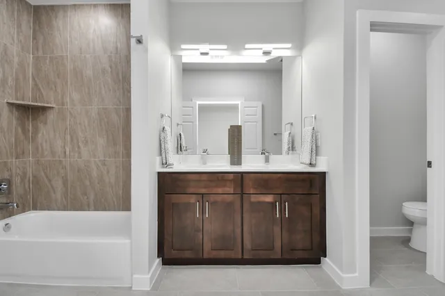 a spacious bathroom with a shower double sink and a mirror