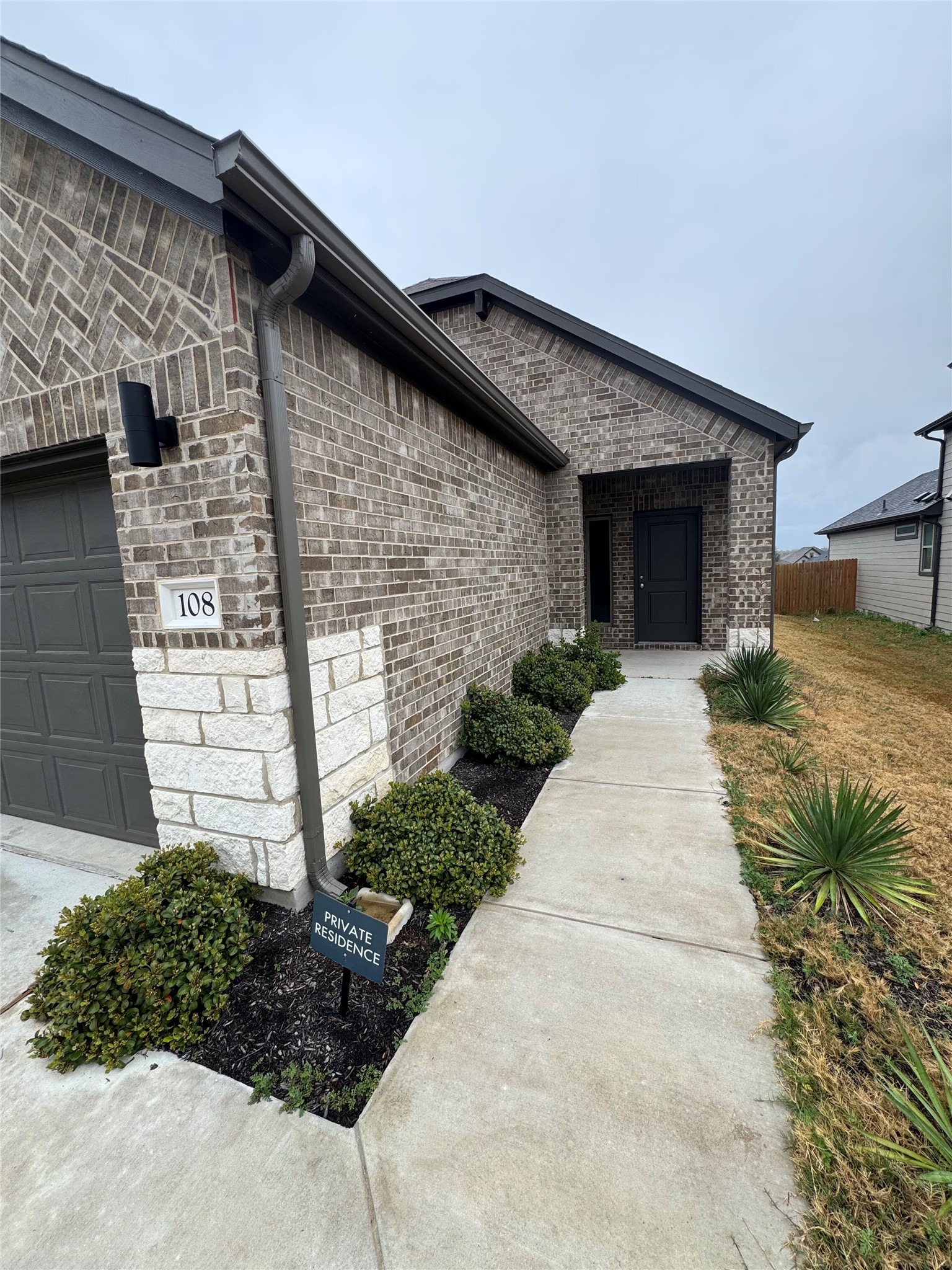 108 Bendecido Loop Elgin, TX 78621 - Photo 2 of 14 a front view of a house with garden