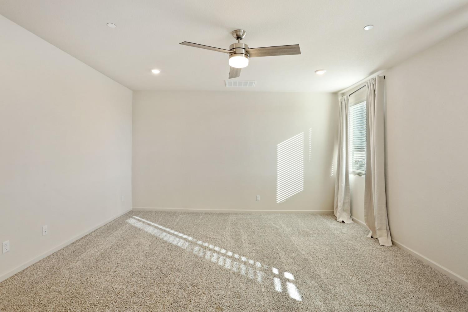 2004 Ravine Lane Manteca, CA 95337 - Photo 14 of 28 an empty room with a ceiling fan and window