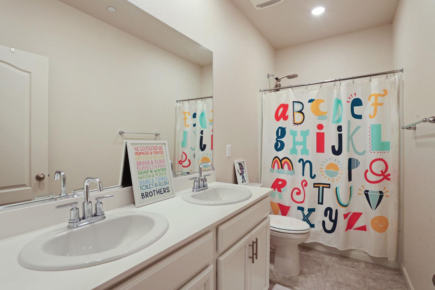 2004 Ravine Lane Manteca, CA 95337 - Photo 22 of 28 a bathroom with a sink a toilet and shower curtain