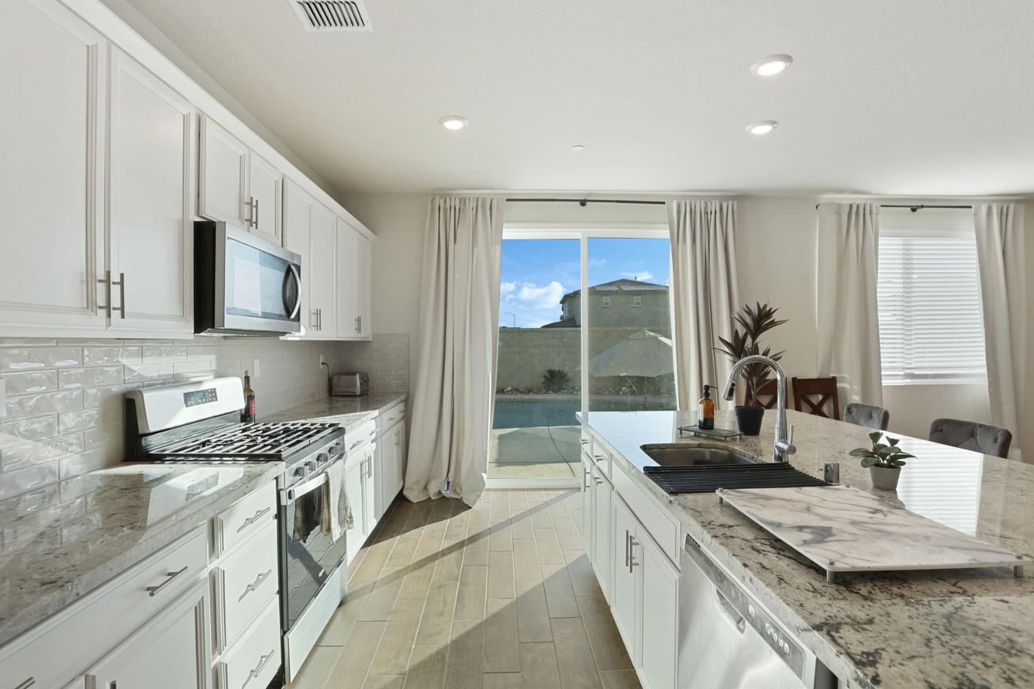 2004 Ravine Lane Manteca, CA 95337 - Photo 9 of 28 a kitchen with stainless steel appliances granite countertop a sink stove and refrigerator