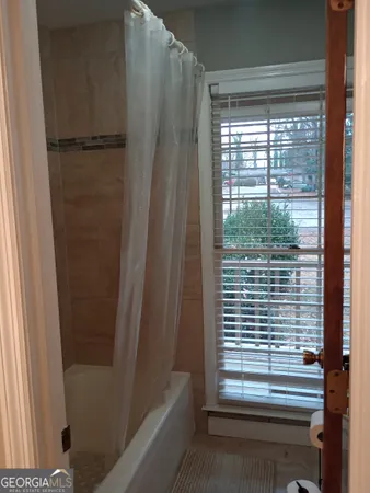 a view of bathroom with a shower and a window