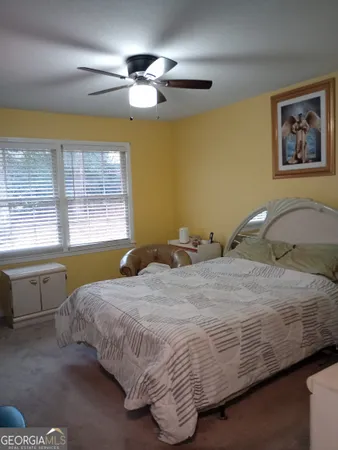 a bedroom with a bed and a large window