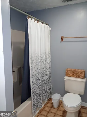 a white toilet sitting next to a shower curtain