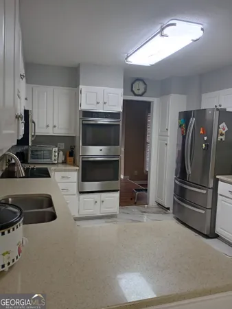 a kitchen with stainless steel appliances a refrigerator a sink a stove and cabinets