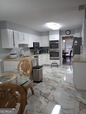 a kitchen with granite countertop a stove and cabinets