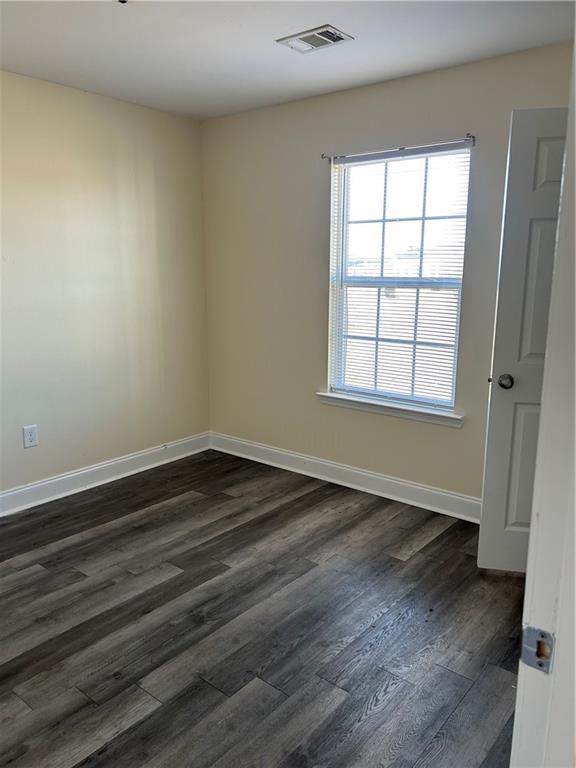 135 Ronald Pride Boulevard Fort Valley, GA 31030 - Photo 7 of 10 an empty room with wooden floor and windows