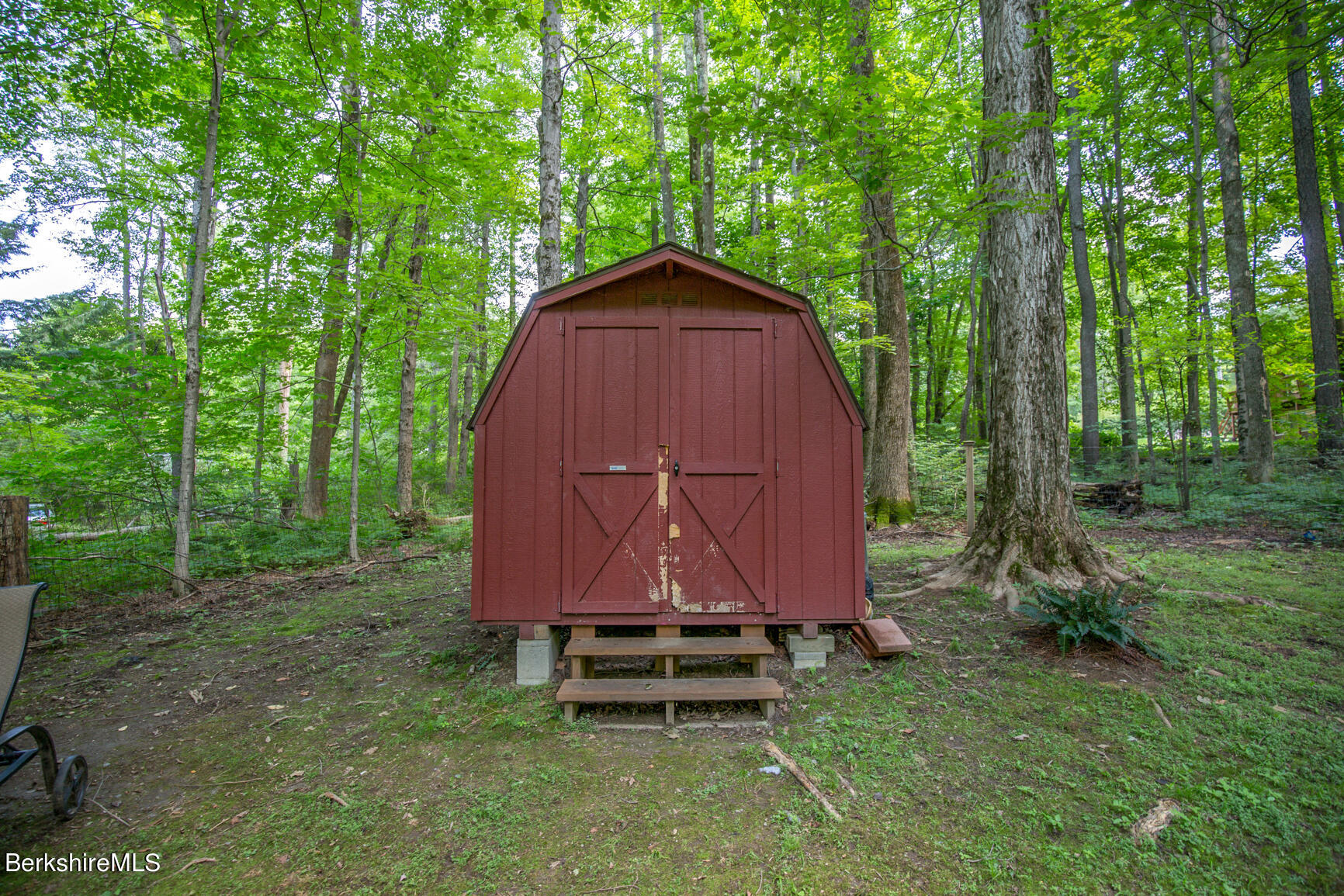 1 Massasoit Road Stockbridge, MA 01262 - Photo 23 of 28 a backyard of a house with large trees and a wooden fence
