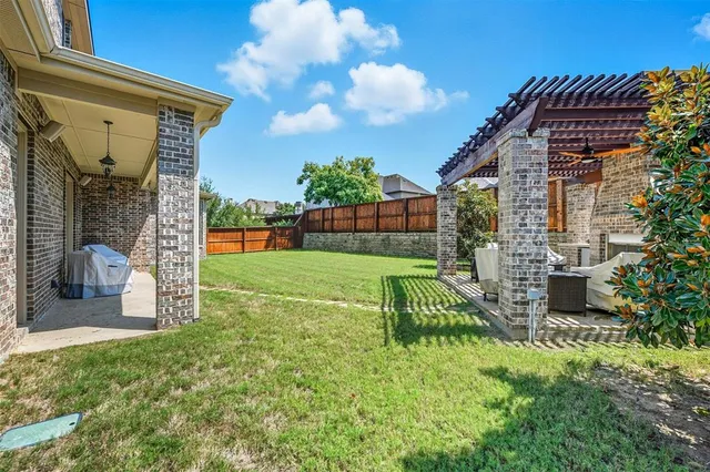 a view of a chair and table in backyard of the house