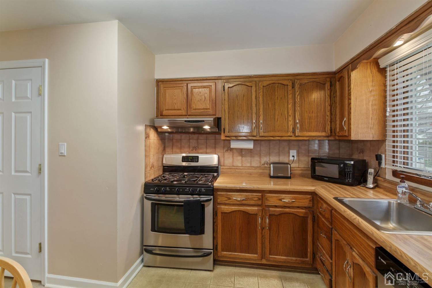 12 Hudson Road East Brunswick, NJ 08816 - Photo 11 of 30 a kitchen with stainless steel appliances granite countertop a sink stove and cabinets