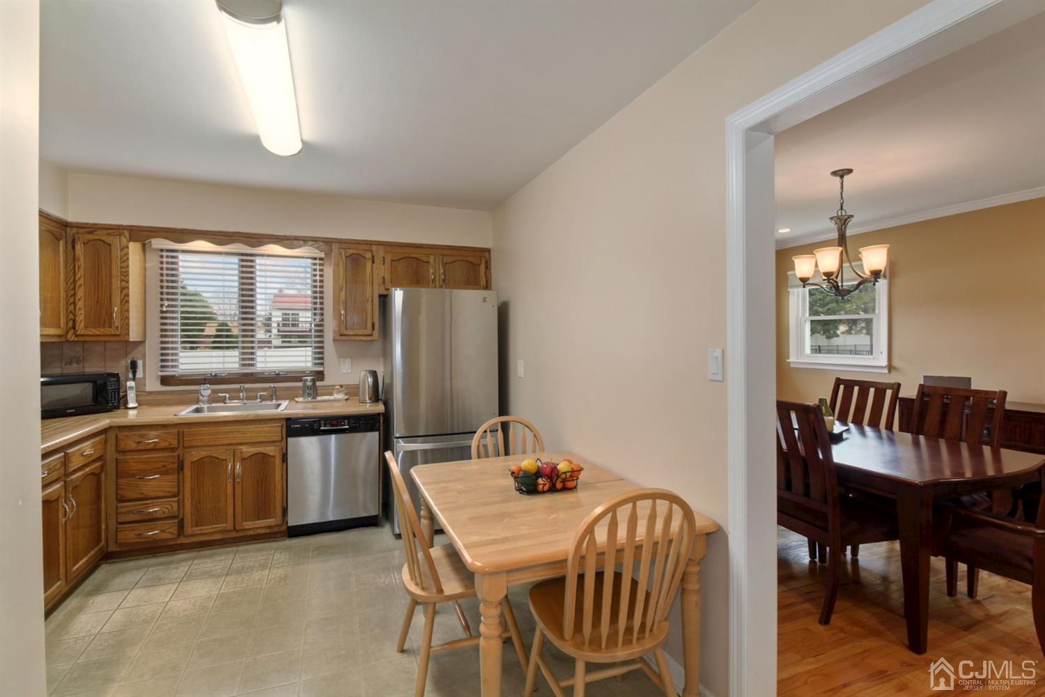 12 Hudson Road East Brunswick, NJ 08816 - Photo 9 of 30 a kitchen with stainless steel appliances granite countertop a dining table chairs and a refrigerator