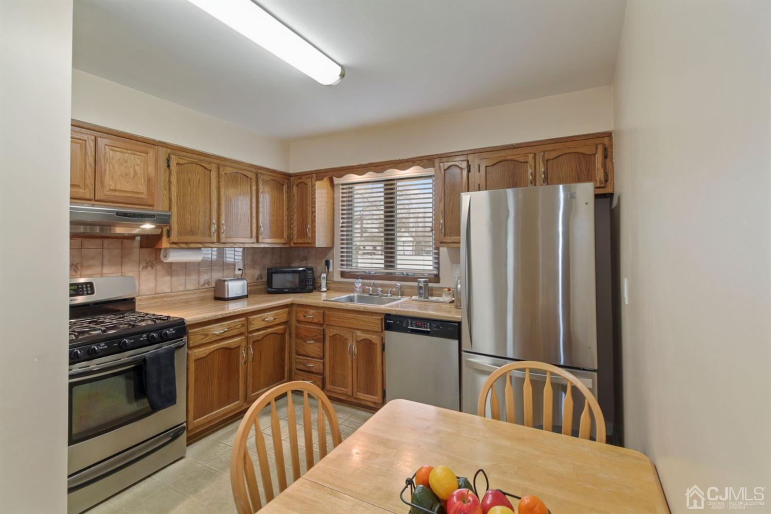 12 Hudson Road East Brunswick, NJ 08816 - Photo 10 of 30 a kitchen with stainless steel appliances granite countertop a refrigerator a sink dishwasher a stove with wooden cabinets and floor