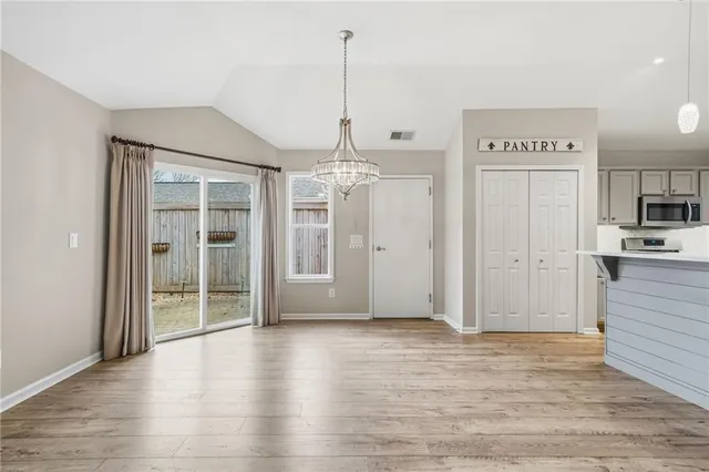 a view of kitchen with stainless steel appliances kitchen island wooden cabinets and granite counter tops