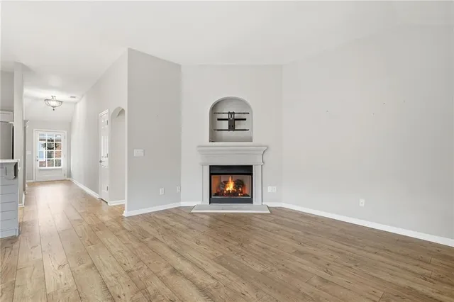 a view of an empty room with a fireplace and a window
