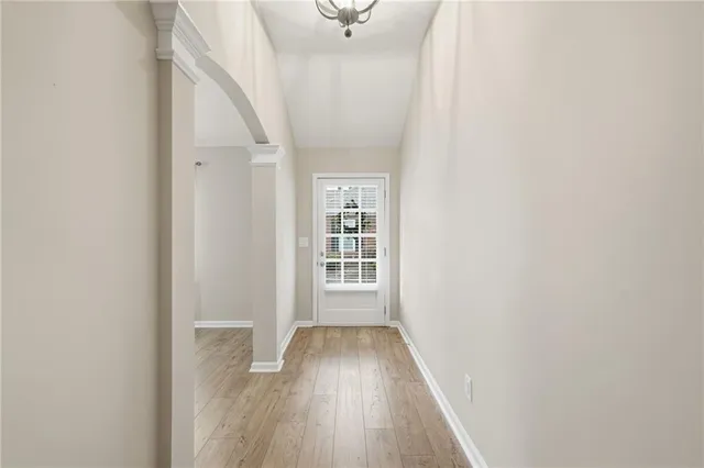 a view of a hallway with wooden floor and a window