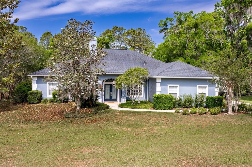 a front view of a house with a yard and outdoor seating