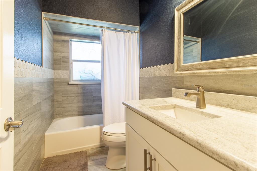 8950 Southeast 17th Court Ocala, FL 34480 - Photo 30 of 61 a bathroom with a granite countertop sink toilet and shower