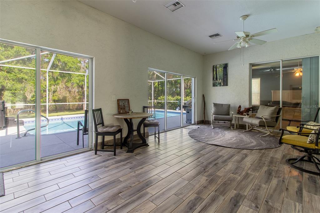 8950 Southeast 17th Court Ocala, FL 34480 - Photo 37 of 61 a living room with furniture a large window and wooden floor