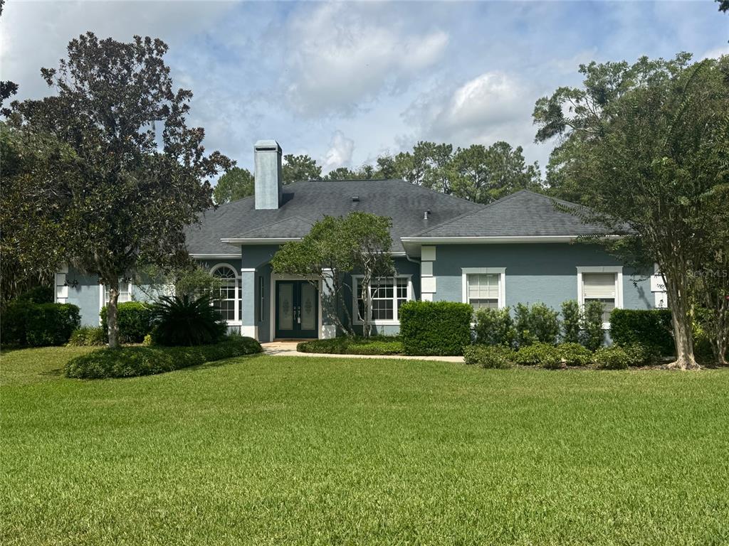 8950 Southeast 17th Court Ocala, FL 34480 - Photo 61 of 61 a front view of a house with a yard and potted plants