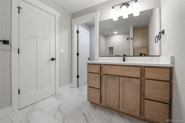 a bathroom with a sink vanity and mirror