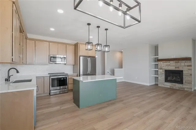 a kitchen with kitchen island a stove a sink and a refrigerator