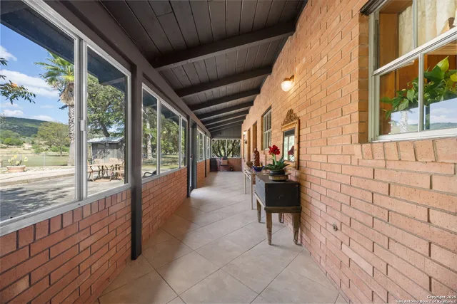 a living room with patio furniture and a potted plant