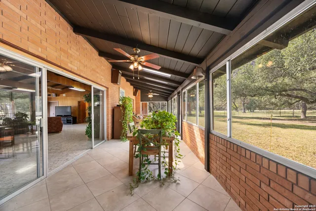 a dining room with furniture and large windows