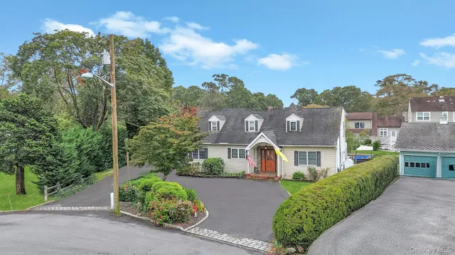 a view of a white house with a yard and table and chairs under an umbrella