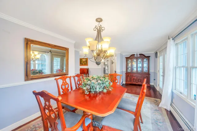 a dining room with furniture a chandelier and wooden floor