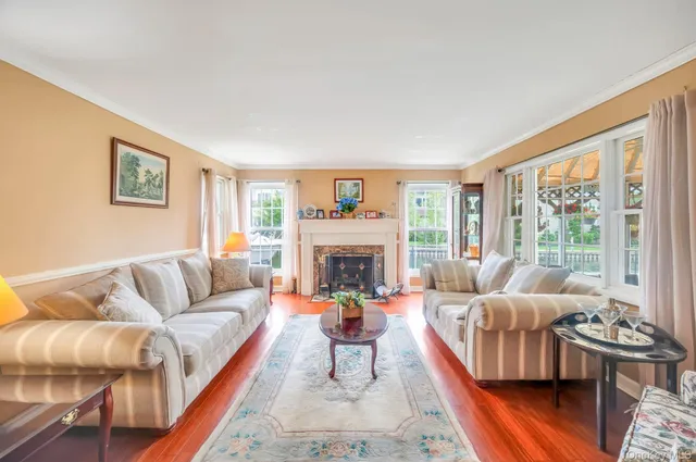 a living room with furniture fireplace and a large window