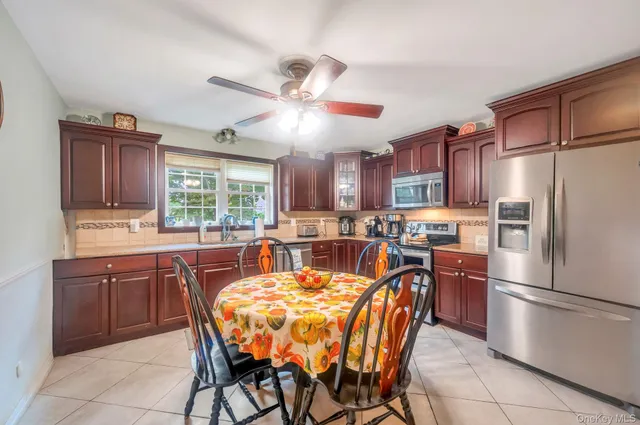 a dining table chair a stove a kitchen island and a refrigerator