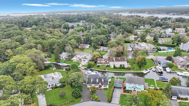 an aerial view of residential houses with outdoor space and trees