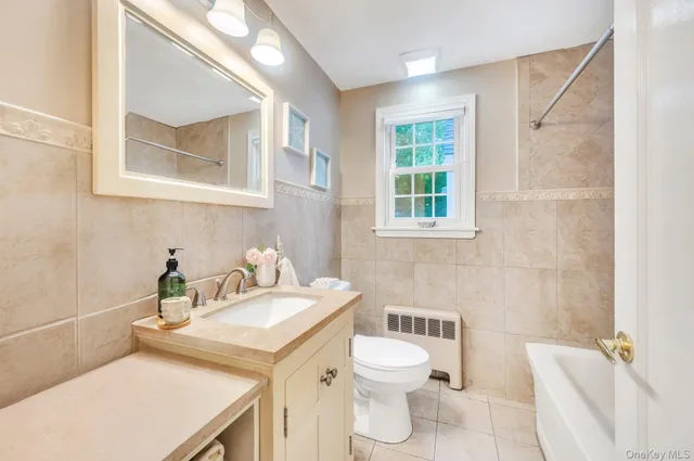 a bathroom with a sink a toilet and a window