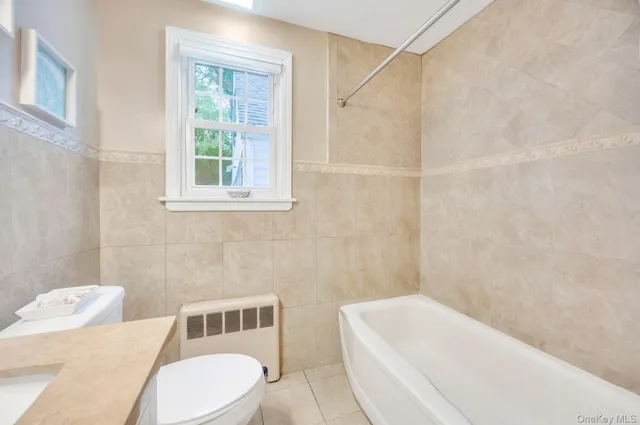 a bathroom with a sink and bathtub with toilet