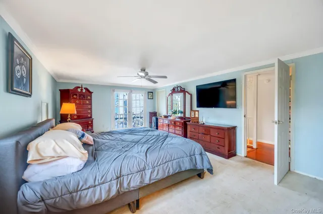 a bedroom with a bed and a flat tv screen on dresser