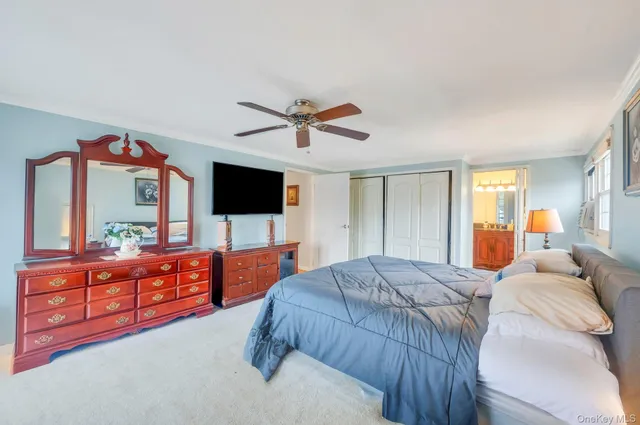 a bedroom with a bed and a flat screen tv with dresser