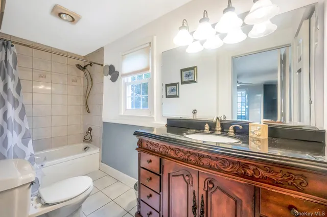 a bathroom with a granite countertop sink mirror toilet and bathtub