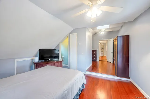 a bedroom with a bed and a flat tv screen on dresser