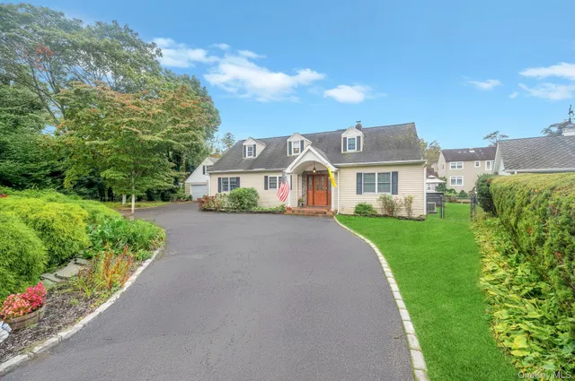 a front view of a house with a yard and potted plants