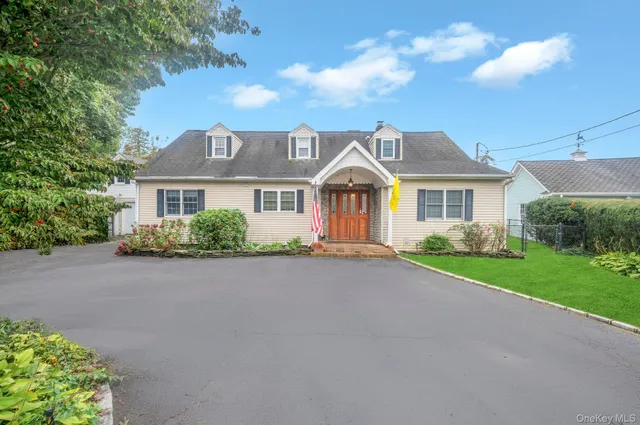 a front view of a house with yard and green space