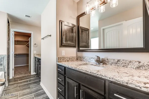 a bathroom with a granite countertop sink and a mirror