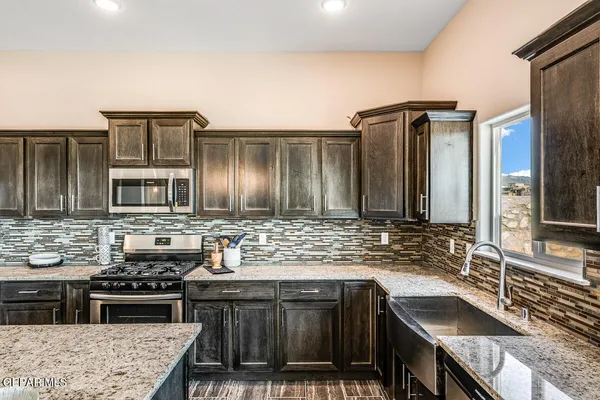 a kitchen with stainless steel appliances granite countertop a sink stove and cabinets