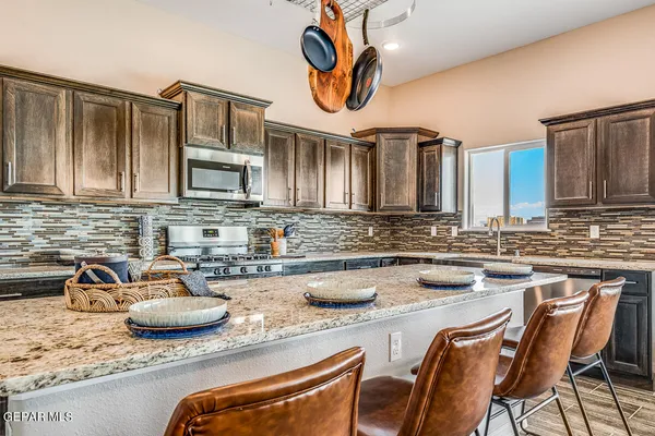 a kitchen with stainless steel appliances granite countertop a sink and a stove