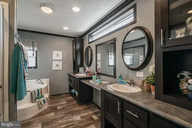a bathroom with a granite countertop double vanity sink and a mirror