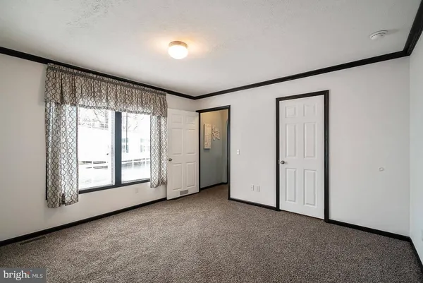 an empty room with windows and closet