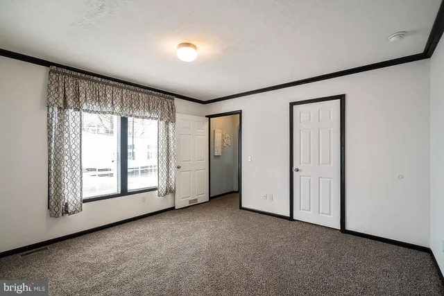 an empty room with windows and closet